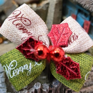 Weihnachtsschleife aus Sackleinen mit roten Beeren und Merry Christmas Aufdruck für Deko
