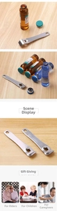 Macro view of stainless steel vial opener showing leverage slot and lanyard hole