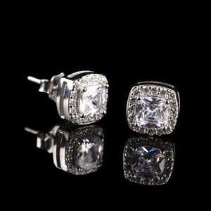 Macro shot of silver halo stud earrings with square cushion-cut zircon and claw setting