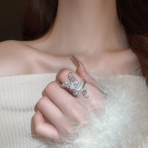 Close-up of elegant silver double butterfly ring with sparkling zircons on model finger