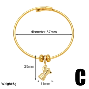 Detalle de brazalete dorado con dije de cafetera y diámetro interior de 57 mm