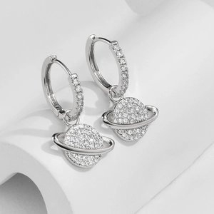 Close-up of silver planet hoop earrings with sparkling cubic zirconia pavé detailing