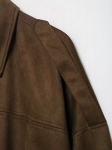 Gros plan détaillé des coutures d'épaule et de la texture en daim de la veste