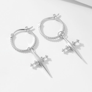 Detailed macro view of 925 sterling silver hoop earrings with textured cross pendants