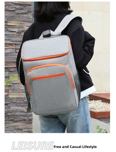 Detail of grey outdoor backpack featuring orange zippers and side mesh pockets in use
