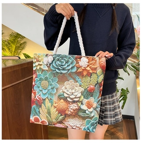 Detail of colorful floral embroidery on a large canvas tote with white rope handles