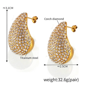Macro detail of teardrop stud earrings in 18K gold-plated titanium with sparkling diamonds