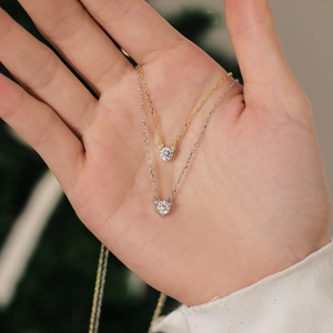 Macro view of gold and silver reindeer antler pendant necklaces with zircon stone