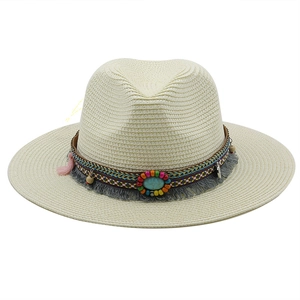 Detail of straw fedora hat featuring colorful beads, turquoise stone and tassels