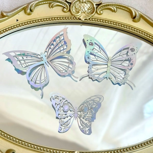 Silver laser holographic hollow butterfly stickers on a vintage gold mirror display
