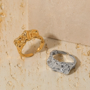 Irregular lava texture open rings in gold and silver metal finish on a stone surface