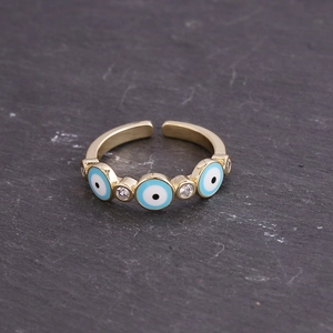 Macro detail of gold plated copper ring with blue evil eye enamel and cubic zirconia