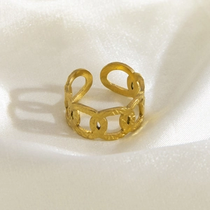 Close-up of a golden chain design ring on white silk background with adjustable open band