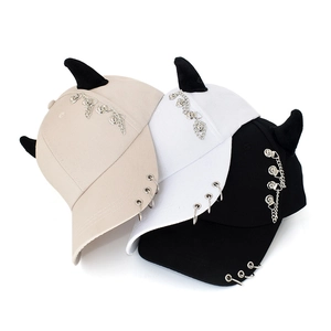 Punk baseball cap with devil horns and metal ring decorations in beige, white and black