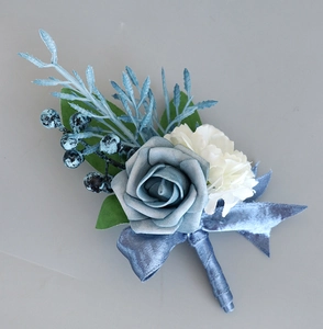 Detail of dusty blue faux rose boutonniere with elegant ribbon wrap and berries