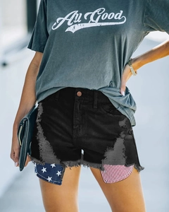 Détail de l'ourlet effiloché et doublure de poche drapeau américain sur short en jean noir