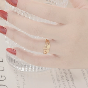 Close-up of elegant gold crown-shaped stainless steel ring worn on a finger