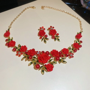 Detail of floral necklace and earrings with red roses green leaves and pearls