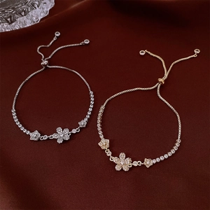 Detail of elegant gold and silver floral bracelets with cubic zirconia on velvet background