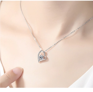 Detailed view of an S925 silver heart necklace with zircon pendant worn on a model's neck