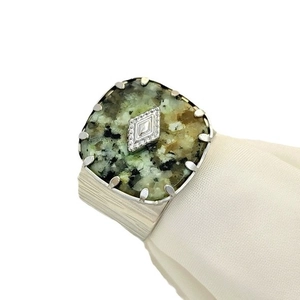 Vintage adjustable stainless steel ring with a square turquoise stone on white fabric