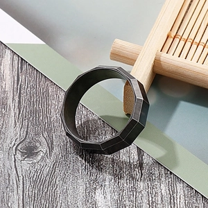 Macro shot of 8mm brushed black stainless steel ring with faceted geometric edges