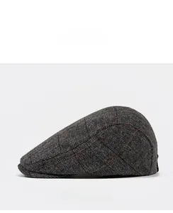 Side view of dark gray herringbone tweed ivy cap with orange plaid patterns