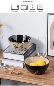 Detail of kiln glazed ceramic bowls with leaf patterns on a rustic wooden table surface