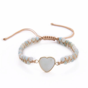 Macro detail of hand-woven emperor stone bracelet with heart pendant and bead textures