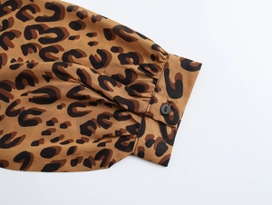 Detail of leopard print dress sleeve with black buttons and ruffled chiffon fabric