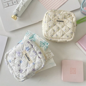 Detailed view of quilted cotton sanitary pad pouches with floral and bear patterns