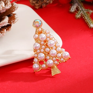 Detailed close-up of golden Christmas tree brooch with white pearls and sparkling rhinestone