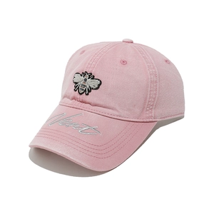 Close-up of pink baseball cap featuring bee embroidery and silver cursive lettering