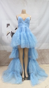 Detail of light blue tiered tulle dress with silver star sequins and high-low hemline