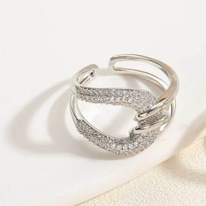 Détail d'une bague réglable argentée avec couches ondulées et pavé de zircones éclatant