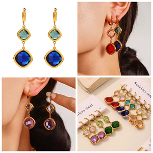 Macro detail of luxury stainless steel earrings with square-cut colored glass stones