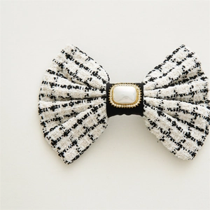 Close-up of a black and white tweed hair clip with a square pearl and rhinestone detail