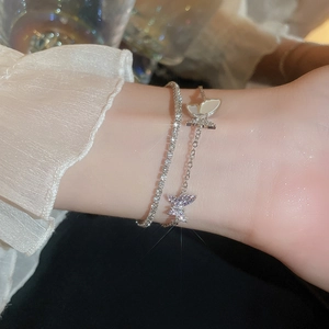 Detail of silver double-layered butterfly bracelet with purple zircon and white shell