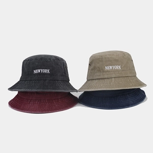 Detail of vintage washed cotton bucket hats featuring breathable metal eyelets and embroidery