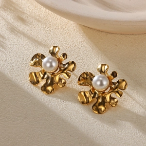 Detailed close-up of vintage gold starfish stud earrings with large white center pearls