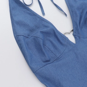 Dettaglio ravvicinato di un abito in denim con fibbia a cuore d'argento e scollo a V