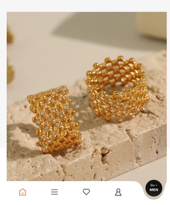 Macro detail of gold-plated titanium rings with honeycomb lattice and sparkling crystals
