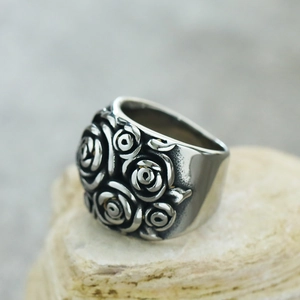 Macro shot of vintage style silver rose relief pattern on wide stainless steel band
