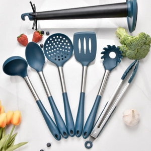 Detailed set of blue silicone kitchen utensils with stainless steel handles on marble