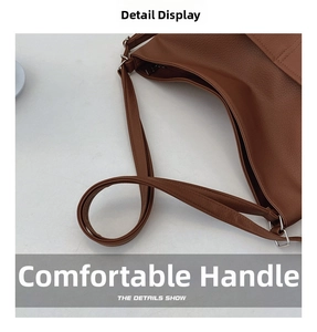 Detail showing the silver metal D-ring and litchi texture on the dark brown tote bag