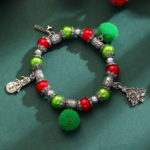 Détail du bracelet de Noël avec perles rouges vertes et breloques de bonhomme de neige
