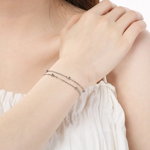 Detail of silver double-layered beaded chain bracelet on wrist with polished finish