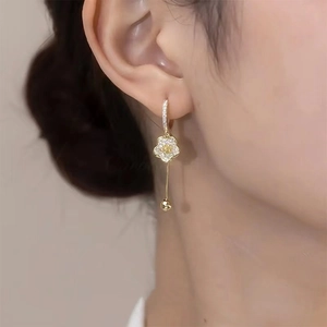 Elegant gold flower drop earrings with zircon crystals on fashion model profile