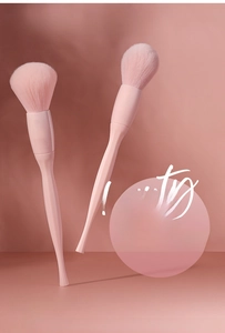 Detail of pink loose powder makeup brush with soft bristles and ergonomic handle design