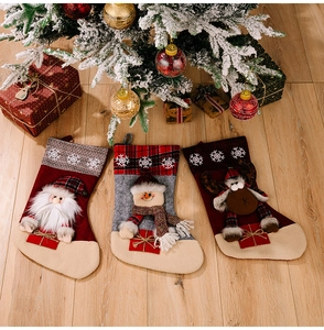 Three Christmas stockings with Santa, Snowman, and Reindeer on rustic wood floor